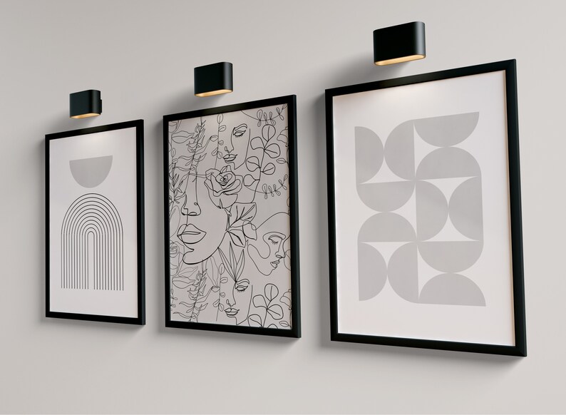 May include: Three black framed prints with white backgrounds and black line drawings. The left print features a half circle and a series of lines forming an arch. The center print features a pattern of overlapping faces and flowers. The right print features a pattern of overlapping semi-circles.