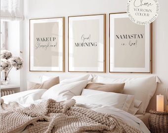 Puede incluir: Tres láminas de pared enmarcadas con fondos beige y texto negro. La primera dice WAKE UP Sleepyhead, la segunda Good MORNING y la tercera NAMASTAY in bed. Una insignia circular indica CUSTOMISE YOUR PRINT Choose YOUR OWN COLOUR.