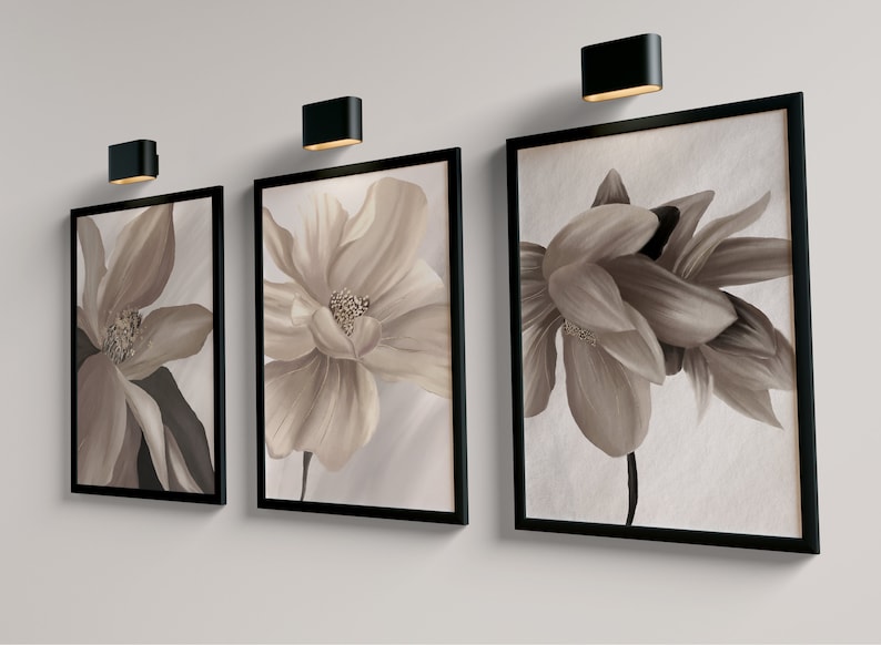 May include: Three framed floral prints with black frames. The prints feature close-up images of beige flowers with brown centers.