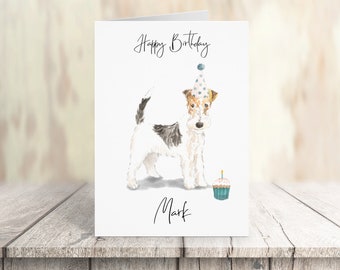 May include: A white and brown wirehaired fox terrier wearing a blue and white polka dot party hat and holding a blue cupcake with a single lit candle. The card reads "Happy Birthday Mark".