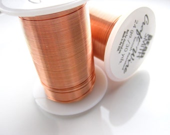May include: A spool of 24 gauge copper wire, 90 yards, by Beadsmith. The wire is wound around a white plastic spool with a label that reads "Beadsmith Craft Wire 24 ga / 30 yds. Not for electrical use. Made in the USA."