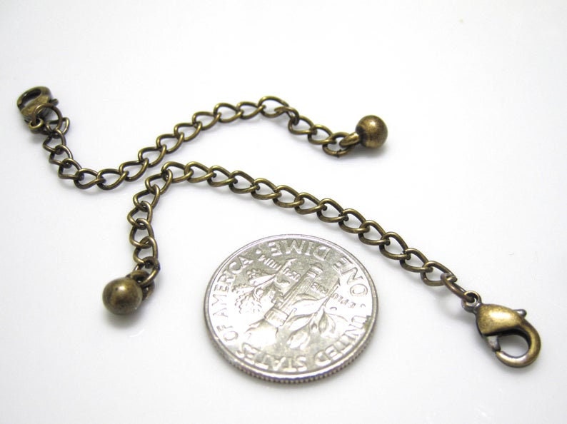 Peut inclure: Un extenseur de cha&icirc;ne en bronze avec deux petites perles rondes et un fermoir &agrave; ressort. La cha&icirc;ne est &agrave; peu pr&egrave;s de la taille d'une pi&egrave;ce de dix centimes d'euro.