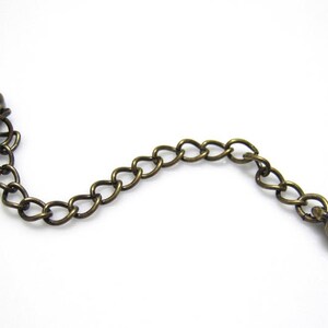 Peut inclure: Une cha&icirc;ne en bronze avec un fermoir &agrave; ressort &agrave; une extr&eacute;mit&eacute; et une perle ronde &agrave; l'autre extr&eacute;mit&eacute;.