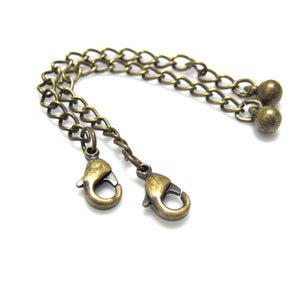 Peut inclure: Une cha&icirc;ne dor&eacute;e avec deux fermoirs &agrave; ressort et deux perles rondes &agrave; l'extr&eacute;mit&eacute;.