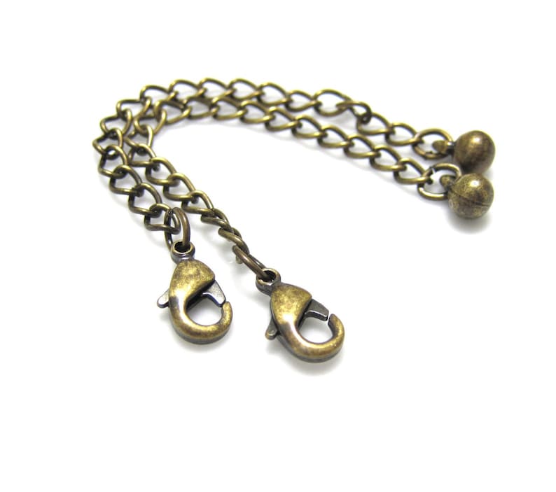 Peut inclure: Une cha&icirc;ne dor&eacute;e avec deux fermoirs &agrave; ressort et deux perles rondes &agrave; l'extr&eacute;mit&eacute;.