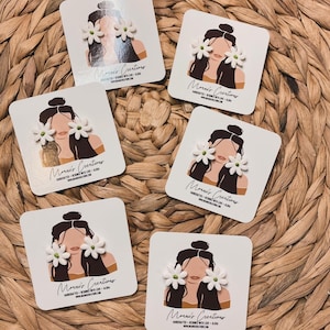 Könnte beinhalten: Fünf weiße Karten mit einer einfachen Linienzeichnung einer Person, die weiße Blumenohrringe trägt. Die Karten tragen den Text "Moravi's Creations".