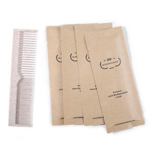 May include: Four brown paper pouches with the text "BBR Bleeker & Rowe" and "Premium 100% Biodegradable Comb" printed on them. A beige comb is next to the pouches.