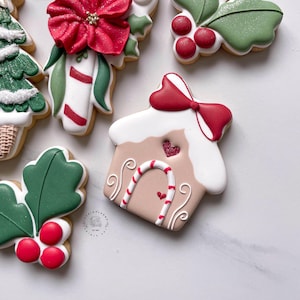 May include: Assortment of Christmas-themed cookies. Includes a gingerbread house cookie with a red bow, heart, and candy cane door. Other cookies feature holly, berries, and a poinsettia. The cookies are decorated with white, red, and green icing.
