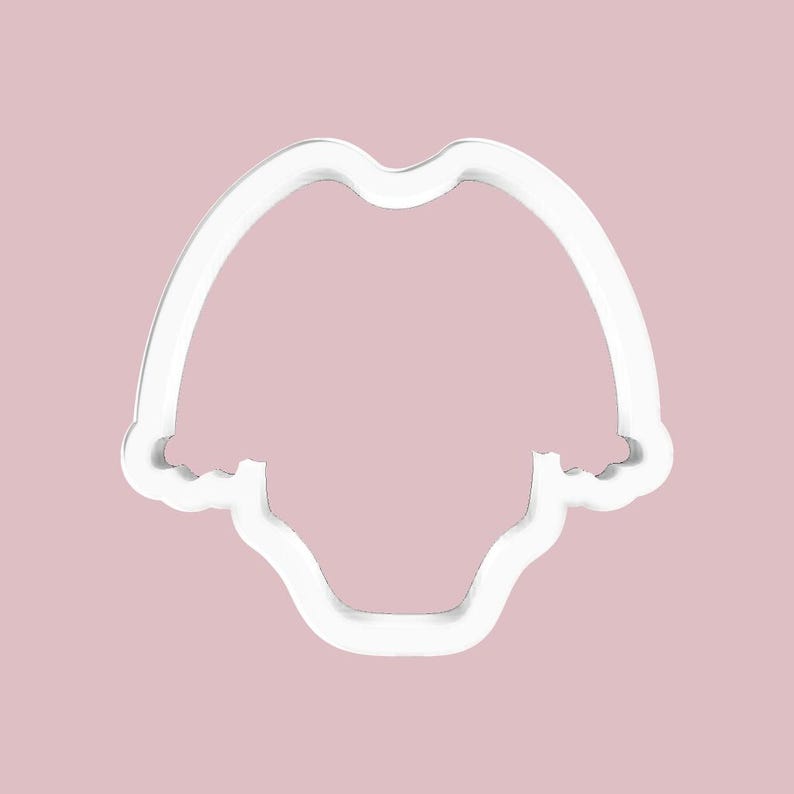 K&ouml;nnte beinhalten: Ein wei&szlig;er Ausstecher aus Kunststoff in Form eines Baby-Stramplers. Der Ausstecher hat eine abgerundete Oberseite und eine gebogene Unterseite. Der Hintergrund ist einfarbig hellrosa.