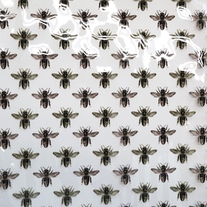 May include: A white surface featuring a repeating pattern of small, detailed black and gray bee illustrations arranged in uniform horizontal and vertical rows across the entire visible area, creating a consistent grid-like visual effect.