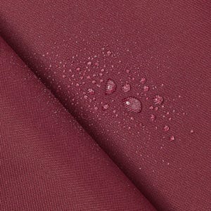 May include: Close-up of a burgundy fabric with water droplets on the surface. The fabric has a textured weave.