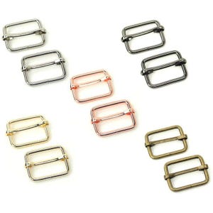 May include: Set of ten metal slider buckles in various finishes, including silver, gold, bronze, and rose gold. The buckles are rectangular with a smooth finish and a center bar.