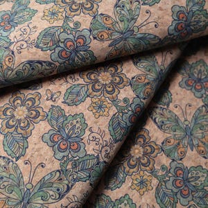 May include: A cork fabric with a repeating pattern of butterflies and flowers in shades of blue, green, yellow, and orange.