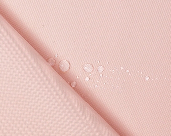 May include: A close-up of a light pink fabric with water droplets on the surface. The fabric is smooth and has a subtle texture.