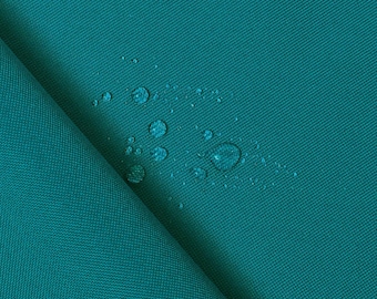 May include: A close-up of a teal fabric with water droplets on the surface. The fabric is textured and has a slight sheen.