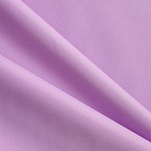 May include: Close-up of a lavender fabric with a subtle texture. The fabric is draped in soft folds, creating shadows and highlights. The color is a light, muted purple, and the material appears to be smooth and possibly synthetic.