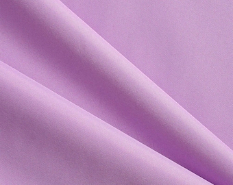 May include: Close-up of a lavender fabric with a subtle texture. The fabric is draped in soft folds, creating shadows and highlights. The color is a light, muted purple, and the material appears to be smooth and possibly synthetic.