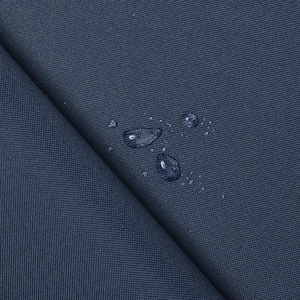 May include: Close-up of a dark blue fabric with water droplets on the surface. The fabric has a textured weave.