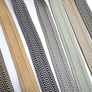 May include: Six different chevron patterned trim ribbons in various colors, including brown, beige, black, gray, and green.