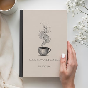 May include: A beige notebook with a black spine featuring a coffee cup illustration with steam rising. The text "CODE. CONQUER. COFFEE." and "DR. LINDSAY" are printed below the cup. A white coffee cup and flowers are in the background.