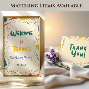 May include: A framed sign and a card with party-themed designs. The sign reads "Welcome to Travis's Birthday Party!" with the date 10.3.2025. The card says "Thank You!" with colorful accents. A sprig of lavender is next to the card.