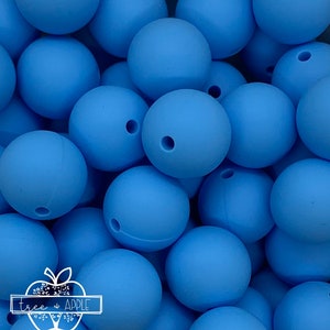 May include: Close-up of a collection of light blue silicone beads. Each bead is round with a small hole, suggesting they are for crafting or jewelry making. The beads are a solid, matte color.