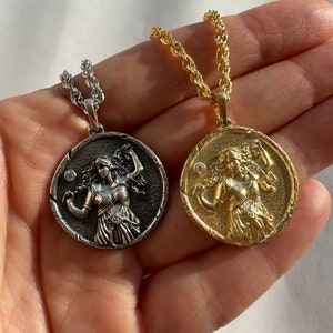 May include: Two necklaces with a rope chain and a round pendant featuring a detailed image of a woman. One necklace has a gold pendant and the other has a silver pendant.