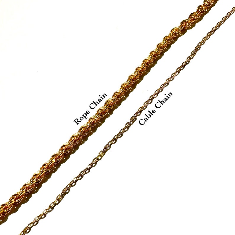 May include: Two gold-colored chains are displayed against a white background. One is a Rope Chain, and the other is a Cable Chain. The Rope Chain is thicker and more textured, while the Cable Chain is thinner and more delicate.