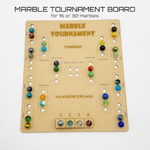May include: A wooden marble tournament board with a brown background and gold lettering. The board has 16 slots for marbles and a championship slot. The board is labeled "Marble Tournament" and "Marbltrak".