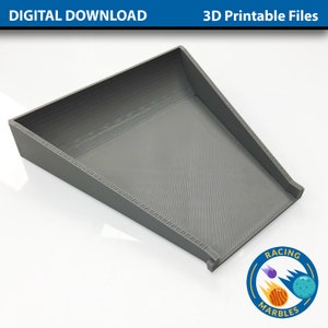 Könnte beinhalten: Eine graue, 3D-gedruckte Rampe für Marmor-Rennen. Die Rampe ist abgewinkelt und hat eine glatte Oberfläche. Das Bild enthält den Text "Racing Marbles".