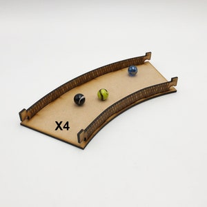 May include: Wooden marble run track with a curved design. The track has a black and white patterned edge. Three marbles are on the track: one blue, one green, and one black and white. The text "X4" is printed on the track.
