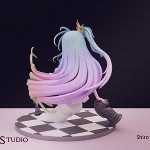 Pu&ograve; includere: Statuetta di un personaggio con lunghi capelli fluenti nei toni del blu e del viola, ornata da una piccola corona d'oro. La figura &egrave; posizionata su una base a scacchi in bianco e nero, con un pezzo degli scacchi. L'etichetta &egrave; "Shiro".
