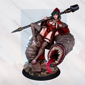 May include: A detailed figurine of a woman in a red hooded outfit, seated on a large, monstrous creature with a gaping maw. The woman holds a staff. The figurine is set on a black base, with a detailed, artistic design.