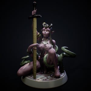 Puede incluir: Figura de fantasía de una demonio de piel púrpura con cuernos, sosteniendo una espada dorada. La demonio está rodeada de tentáculos verdes y se sienta sobre una base circular con un patrón decorativo. La figura tiene detalles intrincados.