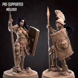 May include: Two detailed figurines of warriors, one female and one male, are depicted. The female warrior holds a spear and shield, while the male figure wears a helmet and carries a spear and shield with a lion emblem. The text "PRE-SUPPORTED INCLUDED" is visible.