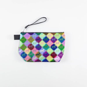 May include: A colorful zippered pouch with a black strap. The pouch is covered in a repeating pattern of multi-colored circles with a silhouette of a horse in each circle.