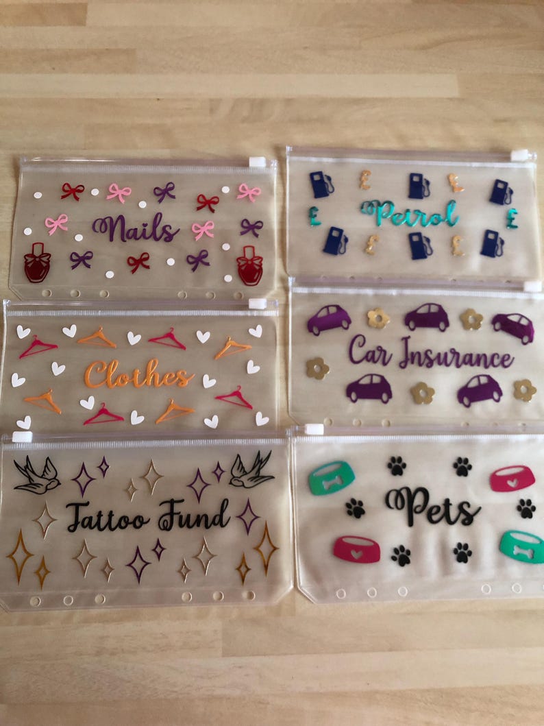 May include: Six translucent plastic zipper pouches with six-hole punched edges. Each pouch features unique vinyl decals and text: Nails with bows and polish bottles, Petrol with gas pumps and pound signs, Clothes with hangers and hearts, Car Insurance with cars and flowers, Tattoo Fund with swallows and stars, and Pets with bowls and paw prints.