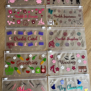 May include: Ten translucent plastic zipper pouches for binders, each featuring unique vinyl decals and text labels including Student Loans, Date Night, Health & Fitness, Health Insurance, Credit Card, Crochet Supplies, Groceries, Waxing, Hair, and Dry Cleaning.