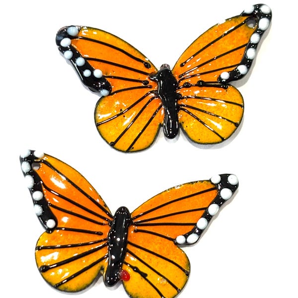 Par de dijes esmaltados con forma de mariposa naranja