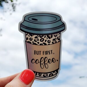 May include: A sticker of a coffee cup with a leopard print design and the text "But first, coffee."