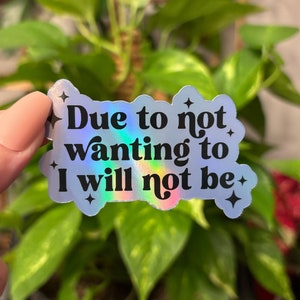 May include: A holographic sticker with the text "Due to not wanting to I will not be" in black lettering.