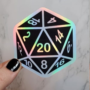 May include: A holographic sticker of a twenty-sided die, used in role-playing games. The die is black with white numbers and a rainbow iridescent border. The number 20 is in the centre.