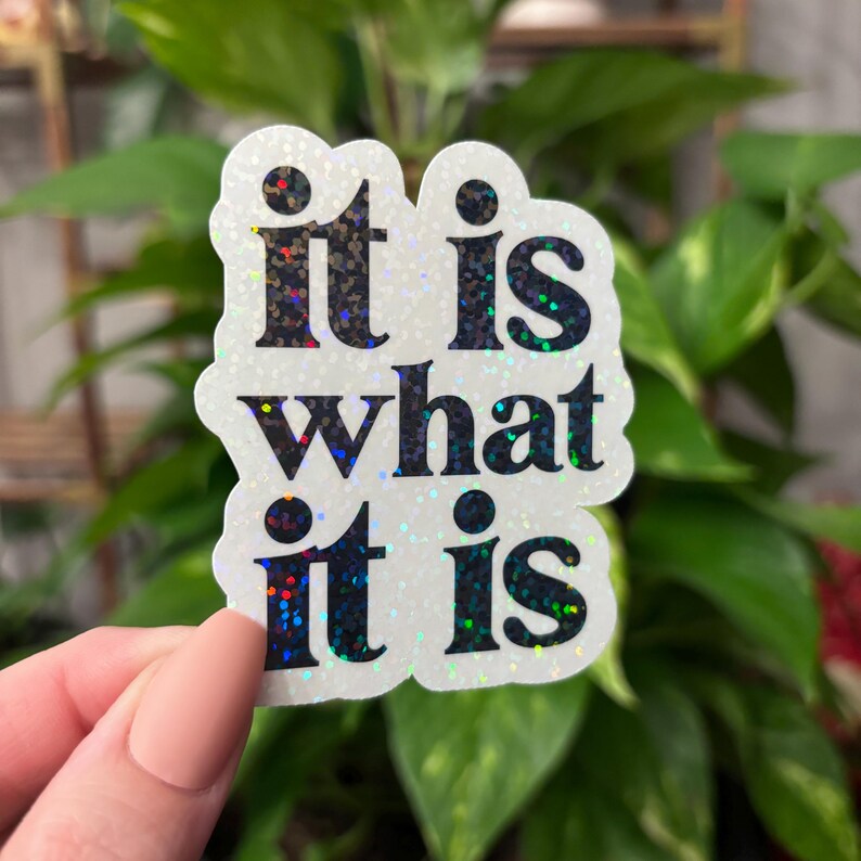 May include: A white sticker with iridescent glitter and black text that reads "it is what it is".