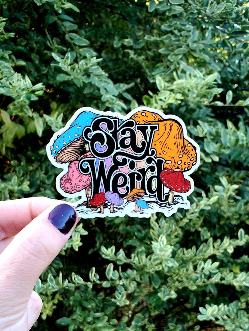 May include: A sticker with a colorful mushroom design and the text "Stay Weird".