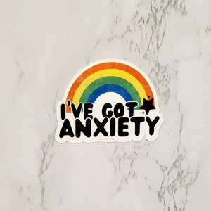 May include: A rainbow sticker with the text "I've got anxiety" in black lettering. The sticker has a distressed look and a star above the text.