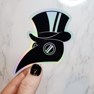 May include: A black and white iridescent sticker of a plague doctor wearing a hat with two stripes. The sticker has a holographic finish.
