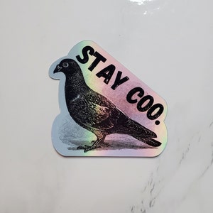 May include: A holographic sticker with a black and white illustration of a pigeon and the text "STAY COO."