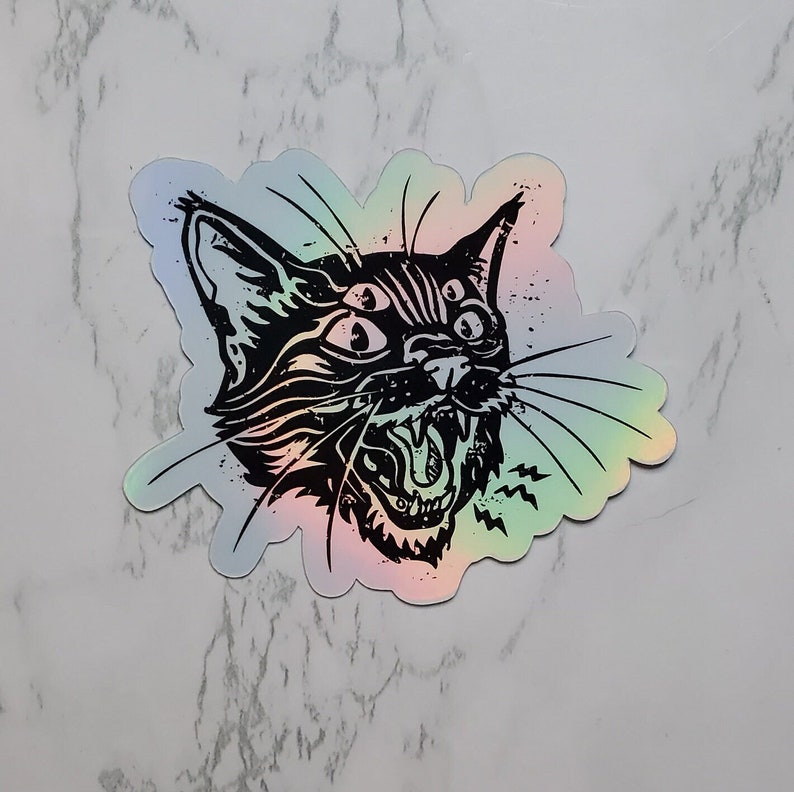 May include: A black and white sticker of a cat with three eyes and an open mouth, set against a holographic background.