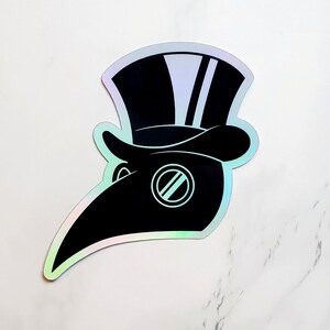 May include: A black and white sticker of a plague doctor wearing a hat with a white stripe. The sticker has a holographic finish.