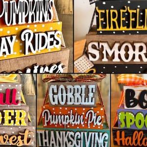 May include: A set of three tiered wooden signs with fall and autumn themes. The top tier says "Pumpkins", the middle tier says "Hay Rides", and the bottom tier says "Harvest". The other signs say "Fireflies", "Smores", "Gobble", "Pumpkin Pie", "Thanksgiving", "Boo", "Spooky", and "Halloween".